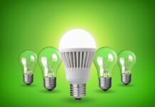 Perché scegliere le lampadine LED: tutti i vantaggi per casa e ufficio Lampadina LED bianca illuminata al centro con quattro lampadine a incandescenza sullo sfondo verde