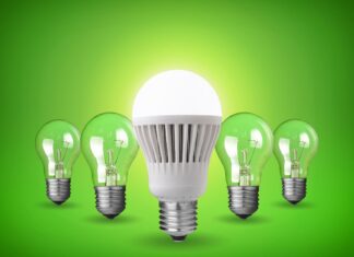 Perché scegliere le lampadine LED: tutti i vantaggi per casa e ufficio Lampadina LED bianca illuminata al centro con quattro lampadine a incandescenza sullo sfondo verde